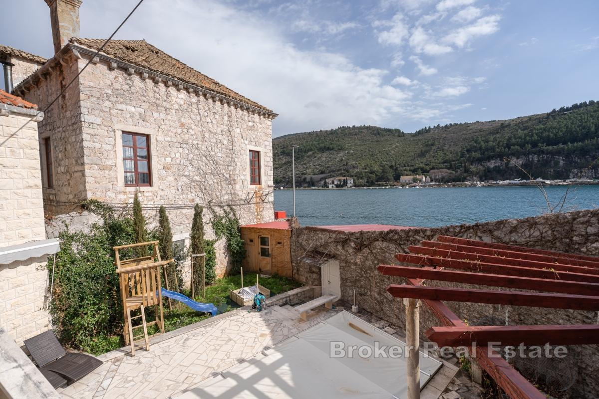 Maison en pierre avec piscine, première rangée de maisons face à la mer