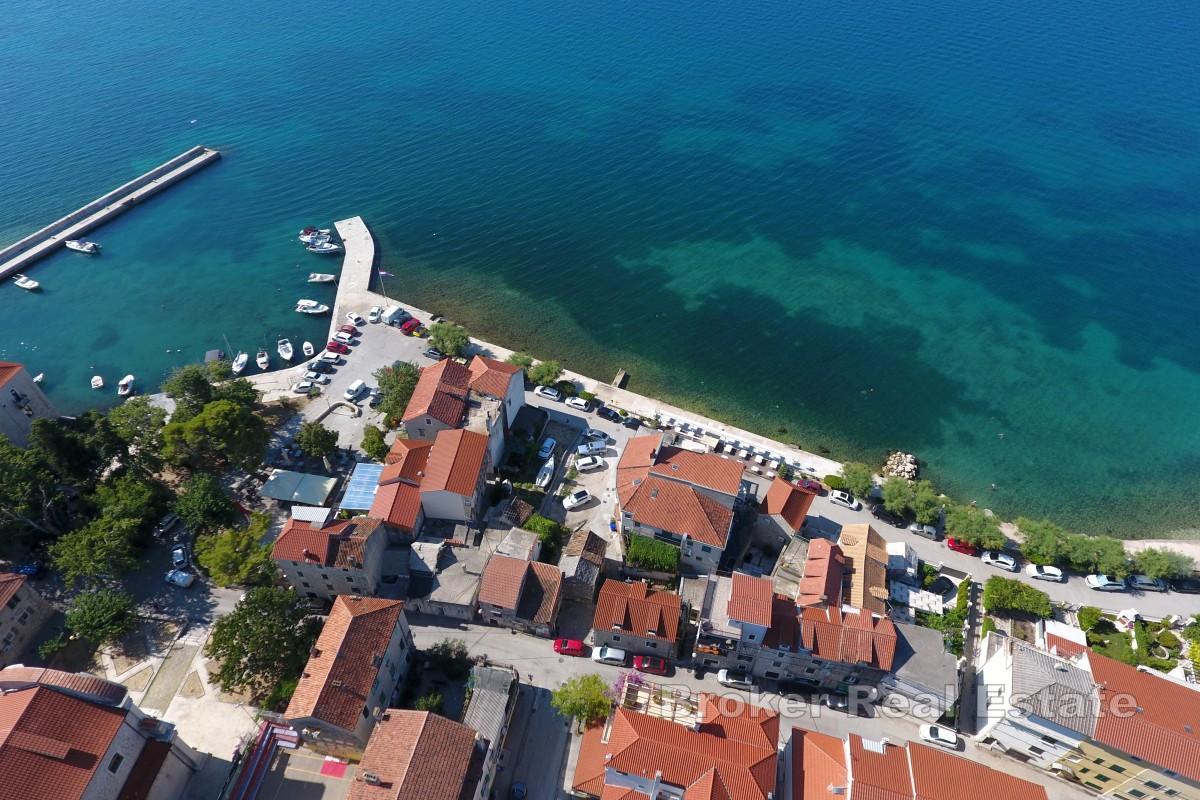 Steinhus for renovering med hage i første rekke mot sjøen