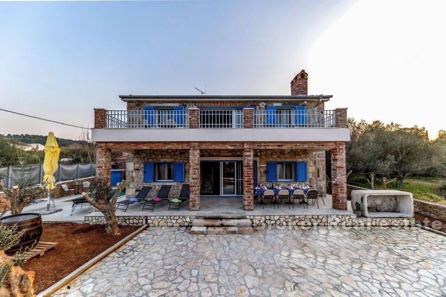 Stenhus med pool i första raden mot havet