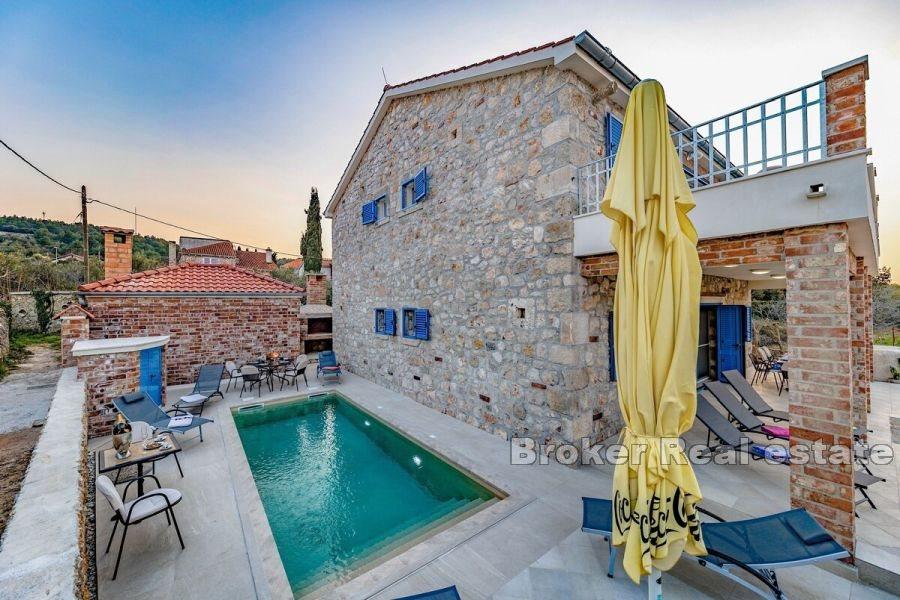 Steinhus med basseng i første rad til sjøen