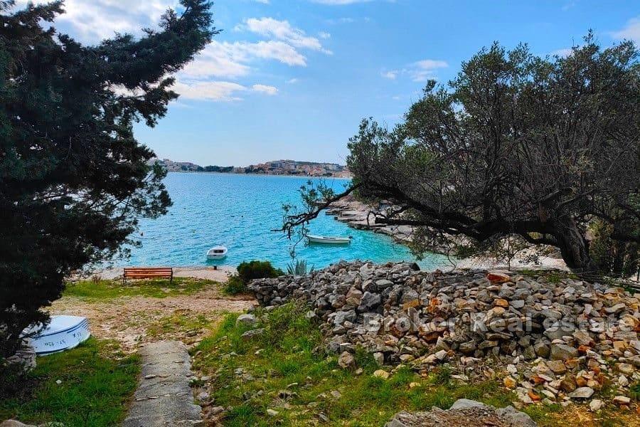 Building plot with a house near the sea