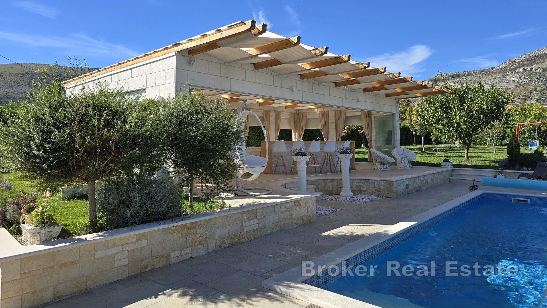 Una bella casa in pietra con un grande giardino e piscina