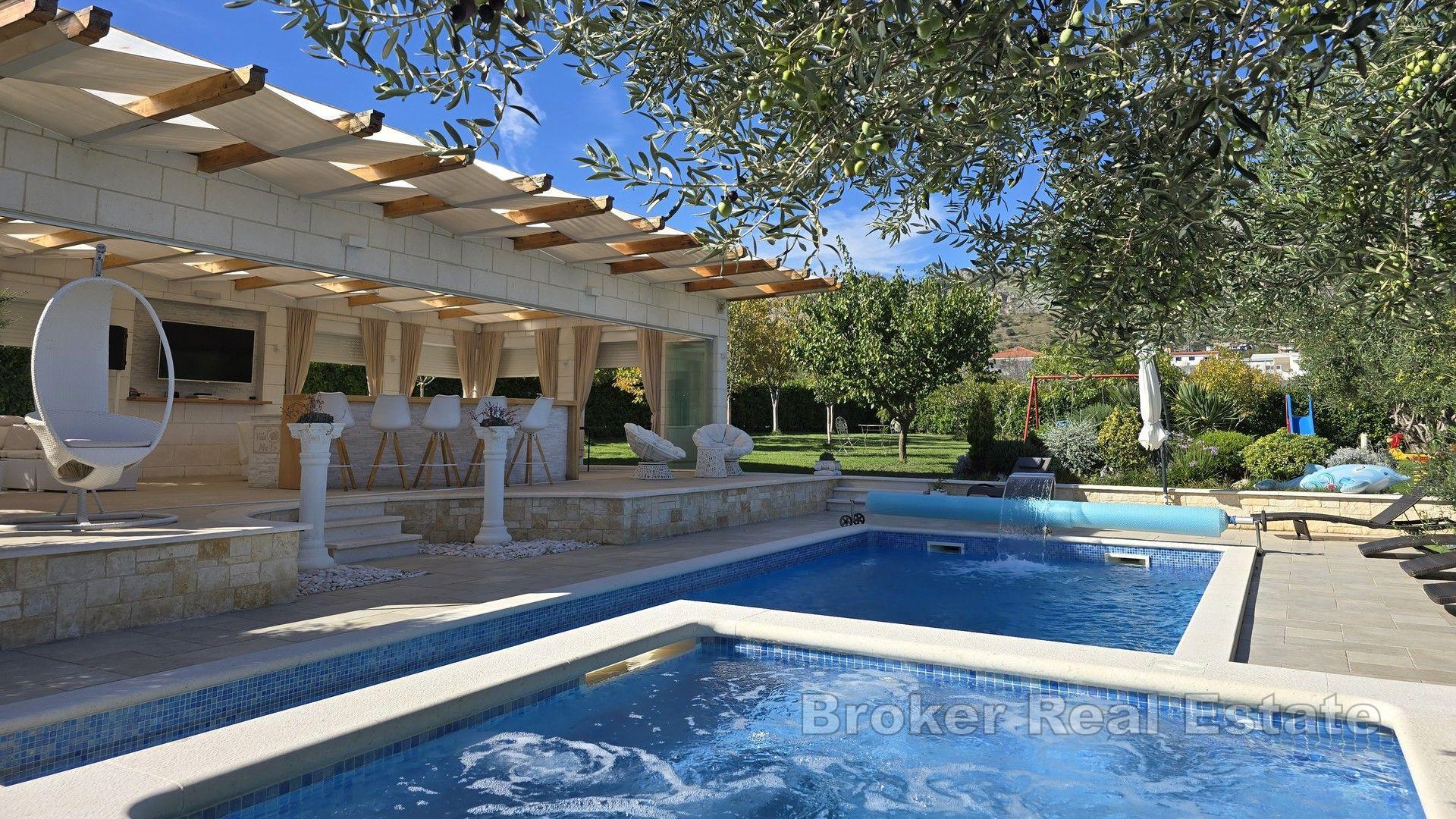 Una bella casa in pietra con un grande giardino e piscina