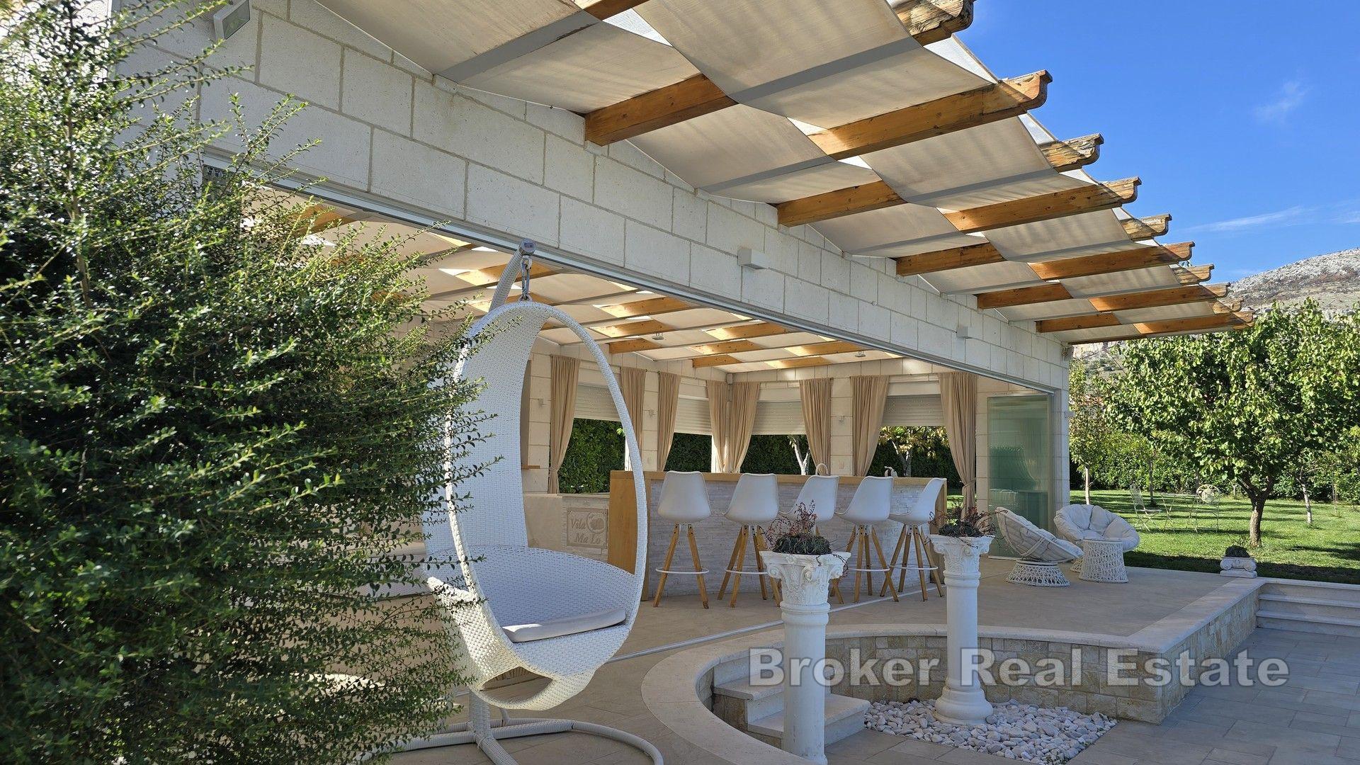 Una bella casa in pietra con un grande giardino e piscina