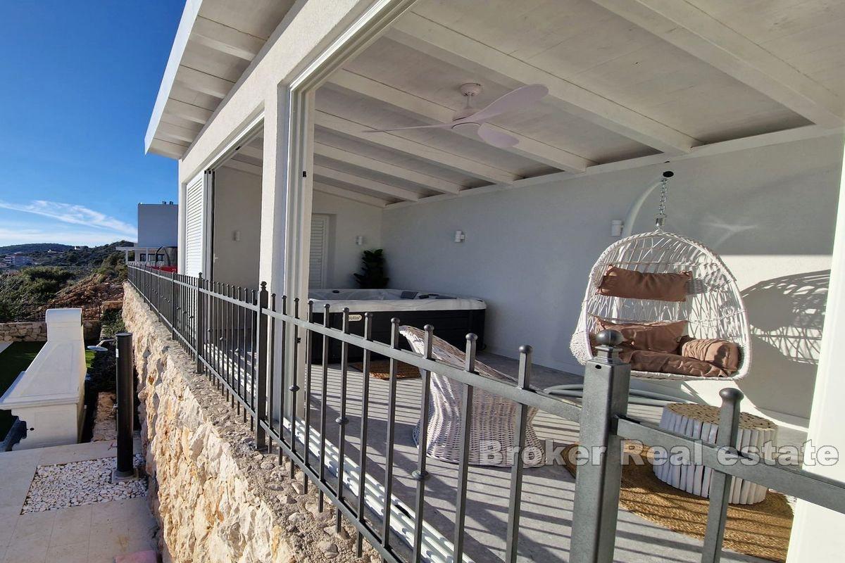 Two smaller houses with a pool and a view of the sea