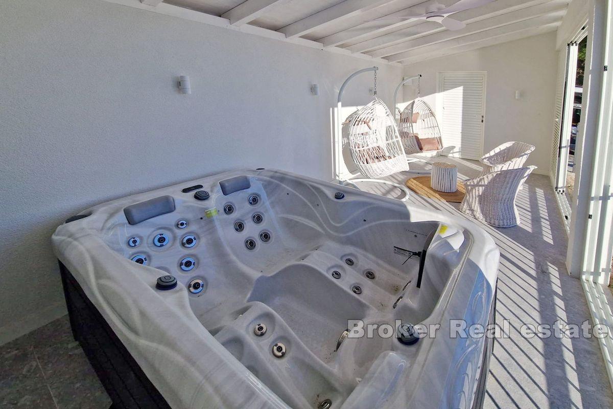Two smaller houses with a pool and a view of the sea