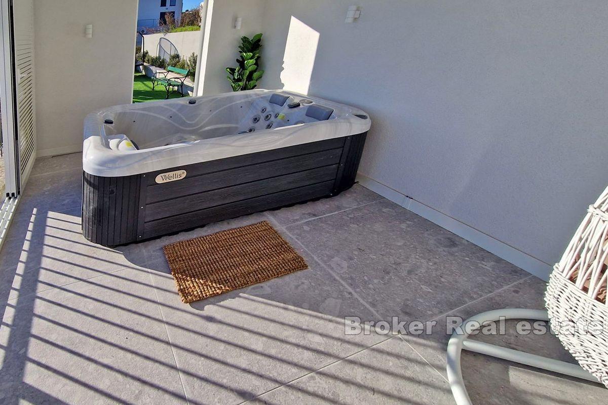 Two smaller houses with a pool and a view of the sea