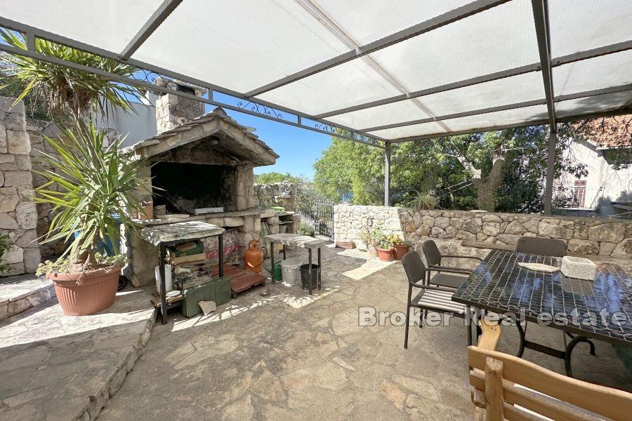 Ein Haus mit zwei Steingebäuden auf einem großzügigen Grundstück