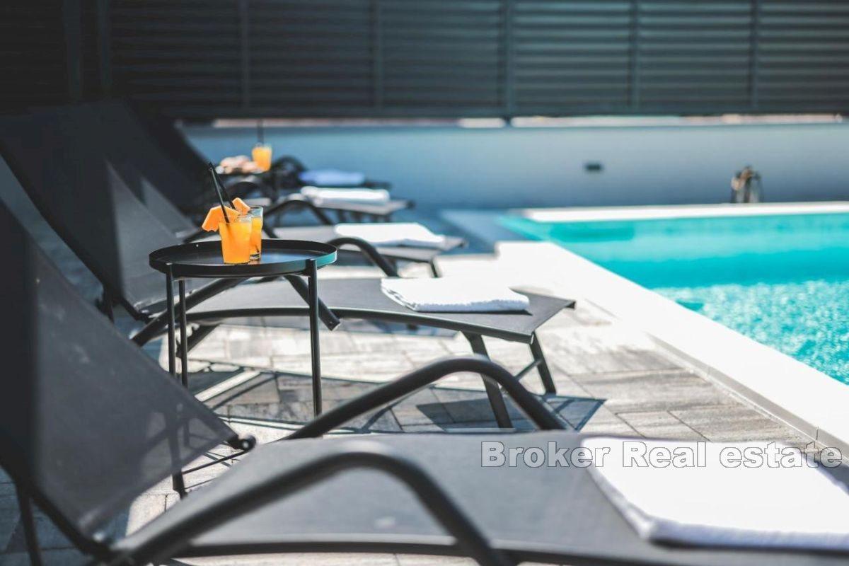 En villa med en vacker trädgård och pool nära centrum