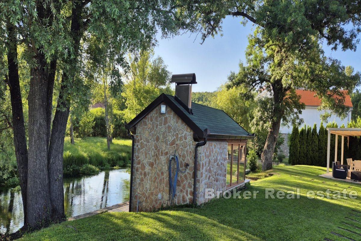 Detached house by the river with a pool and landscaped garden