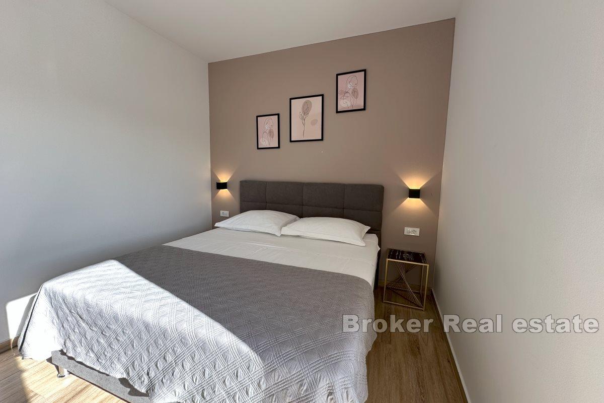 Modernt inredd lägenhet med ett sovrum och en rymlig terrass