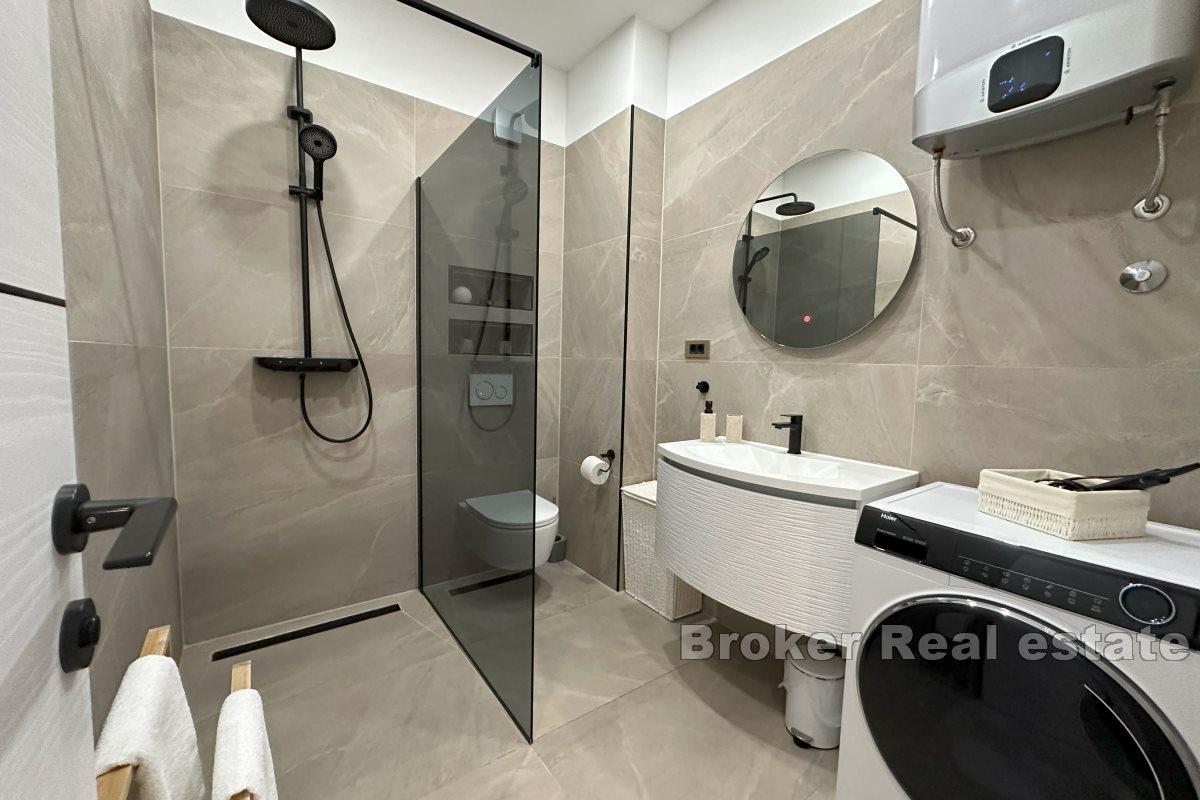 Modernt inredd lägenhet med ett sovrum och en rymlig terrass