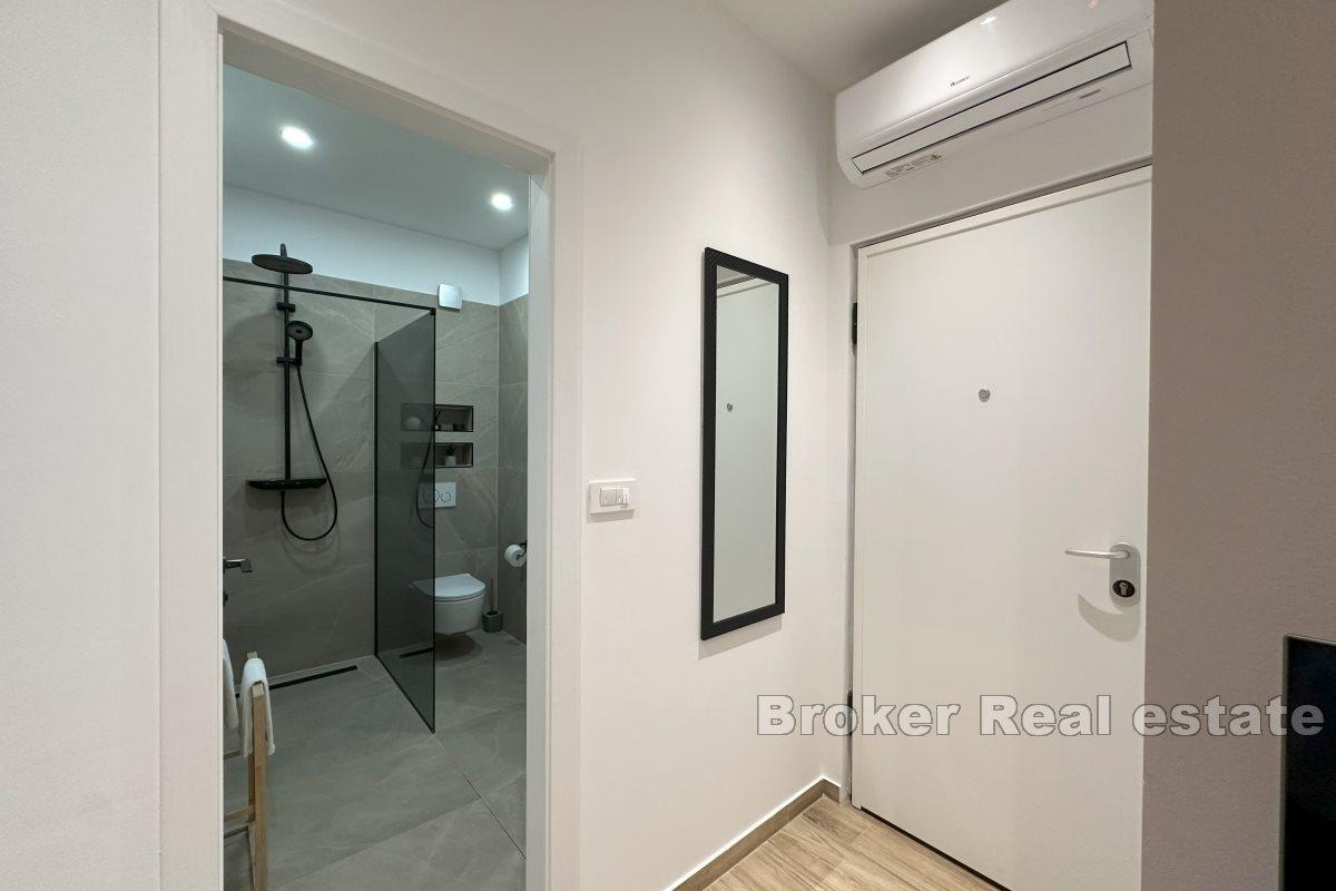 Modernt inredd lägenhet med ett sovrum och en rymlig terrass