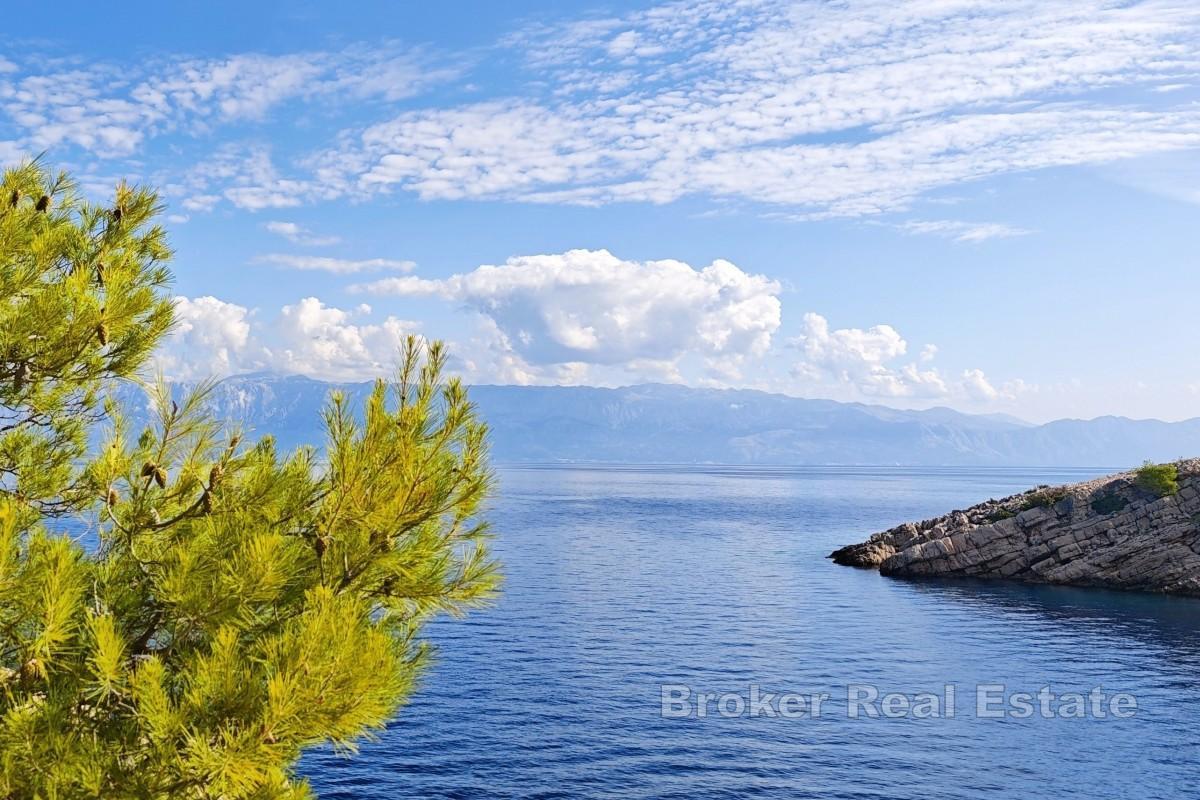 Jordbruksland med steinbygning - første rad mot sjøen