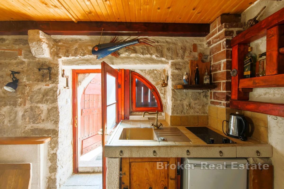 Rustikt stenhus med öppen spis och terrass, nära havet