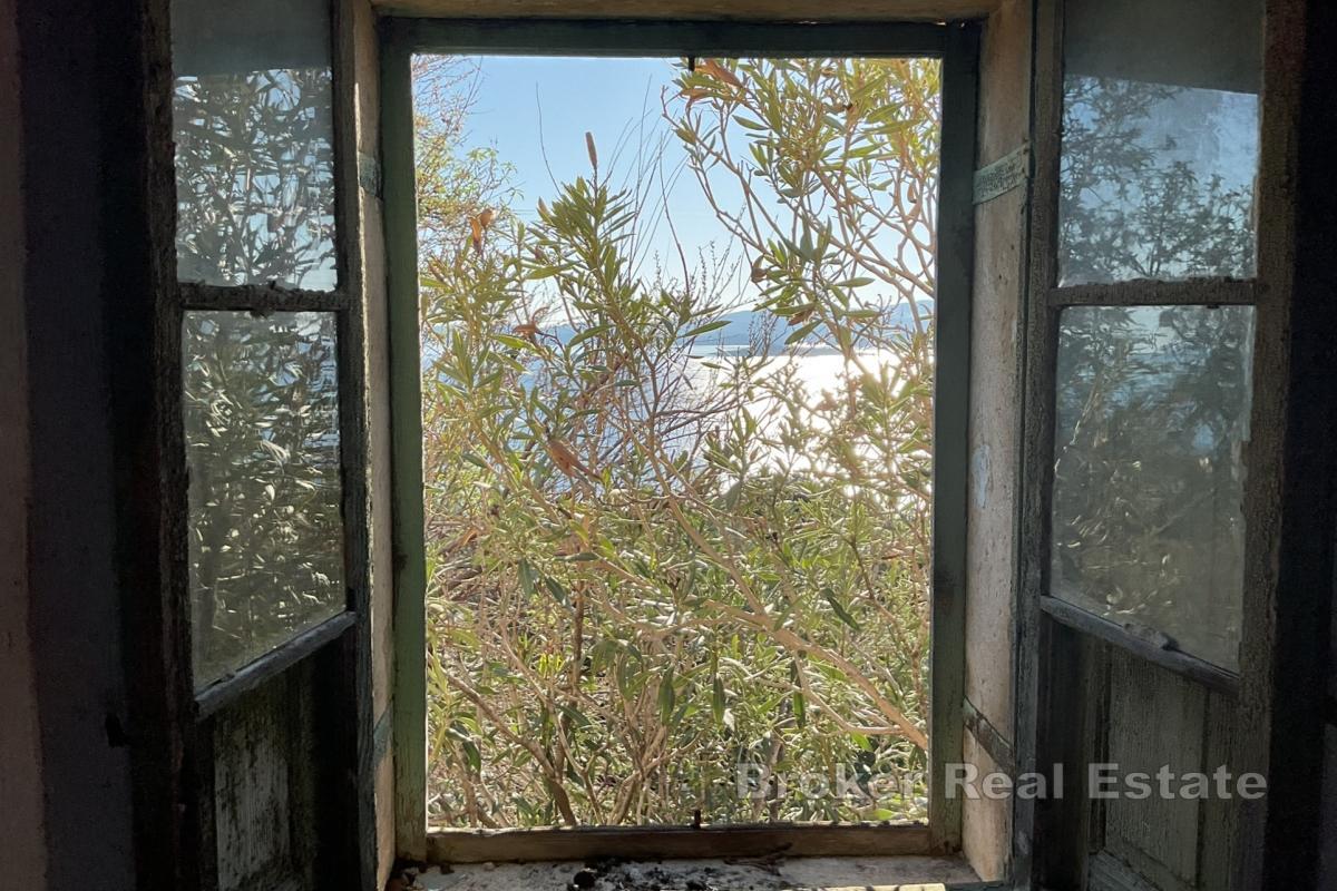 Gammelt steinhus med land ved sjøen