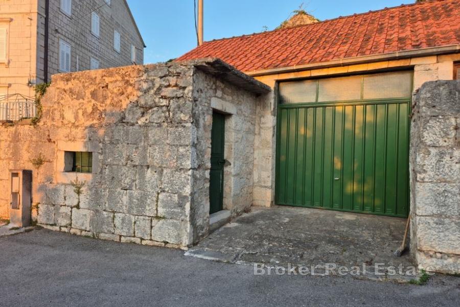 Förstörda stenhus med garage och uthus
